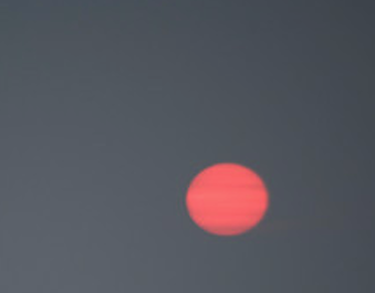 Red ball of sun on gray